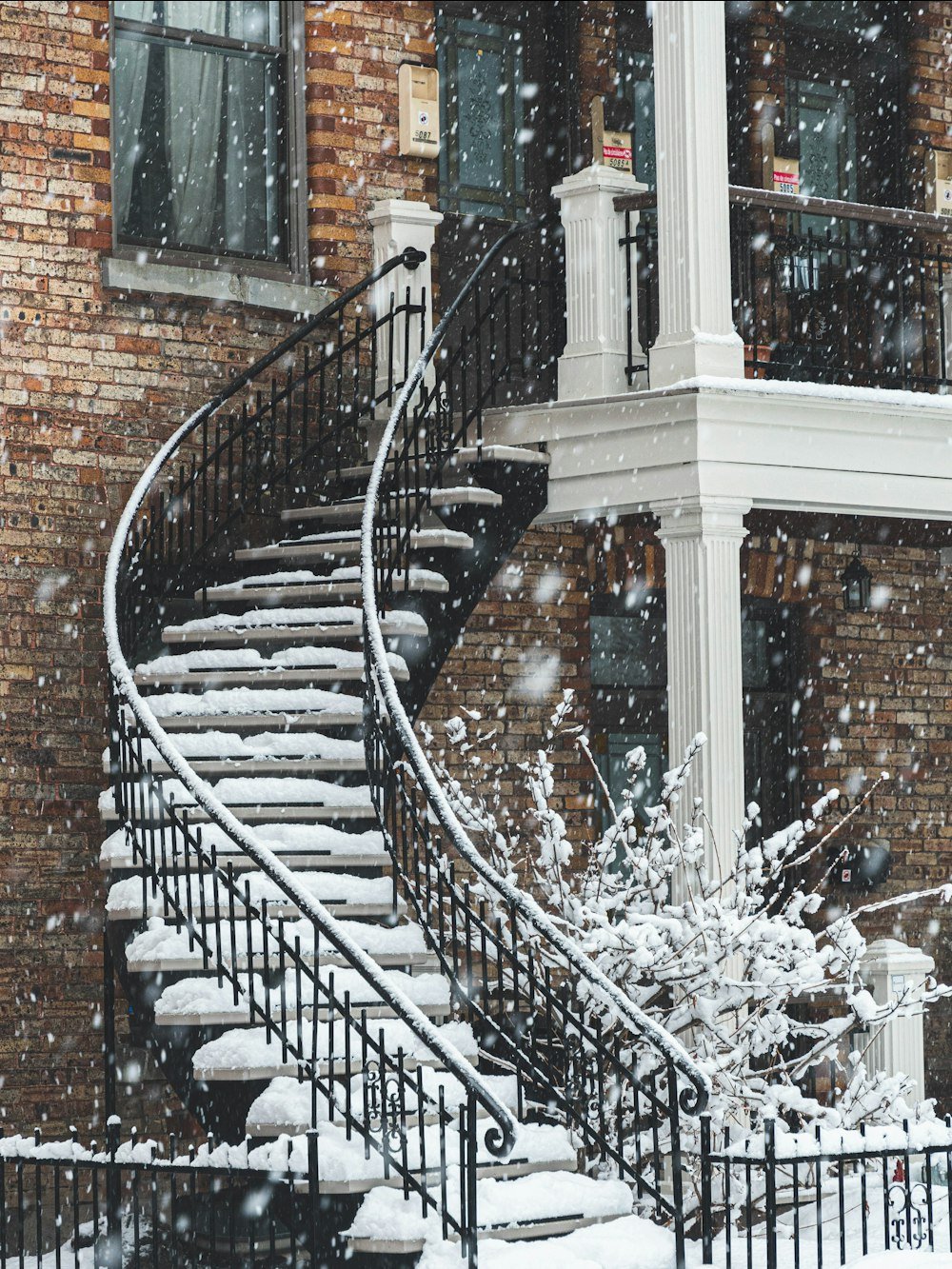 Escalier extérieur en colimaçon sous la neige, typique de Montréal